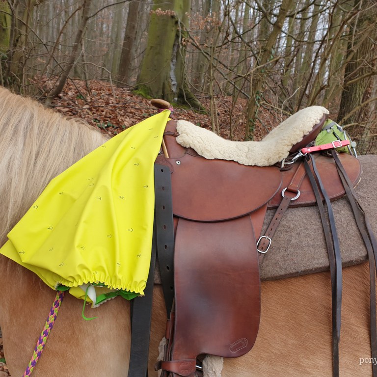 Der Latz vom Regenreitrock am Sattel